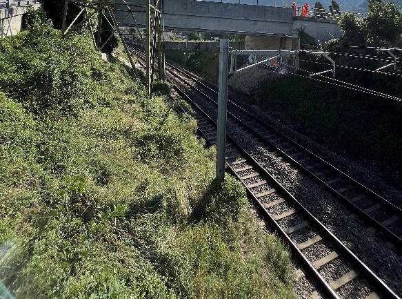 Voie ferrée sous un pont routier à côté du pylône avec l’antenne radio